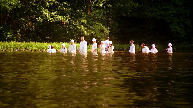 在洗礼仪式上，人们站在湖中央等待被浸泡在水里/费尔法克斯站，美国弗吉尼亚州视频下载