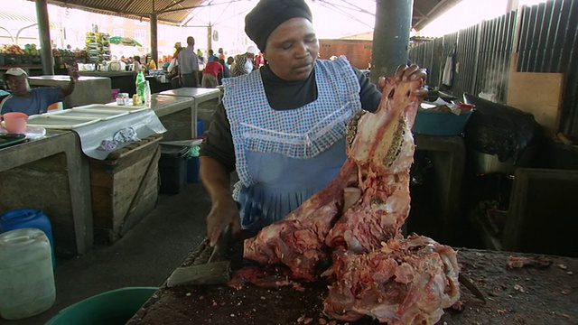 南非德班沃里克市场，一名妇女正在切牛头视频素材