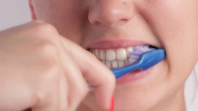 正在刷牙的快乐年轻女子。视频素材