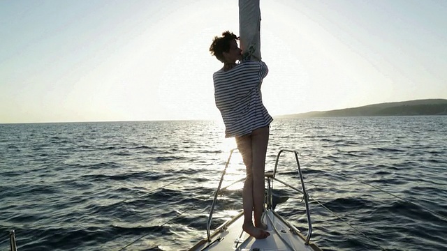 年轻女子向帆船船头走去。视频素材