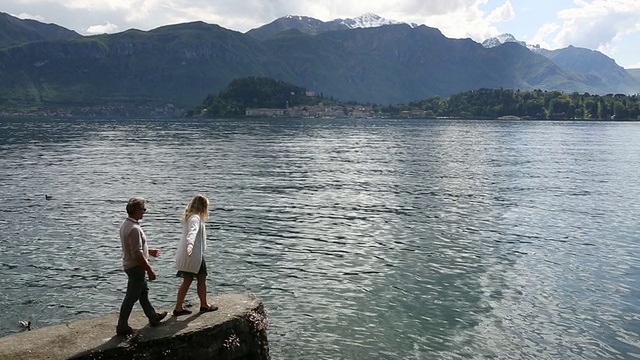 夫妇俩走到湖上的石墙尽头，往外看视频下载