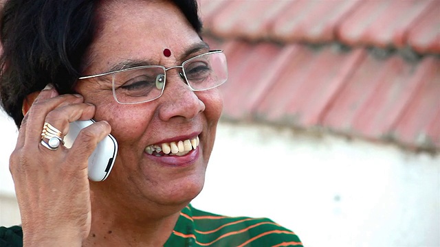 年长的印度亚裔女性正在打手机视频素材