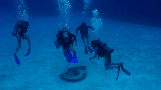 潜水小组正在检查海床上的结构视频素材