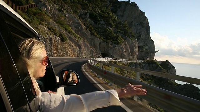 女人从车窗伸出手臂，沿海岸行驶视频下载
