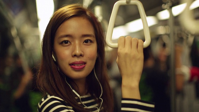 一名女子在火车上听音乐。视频素材