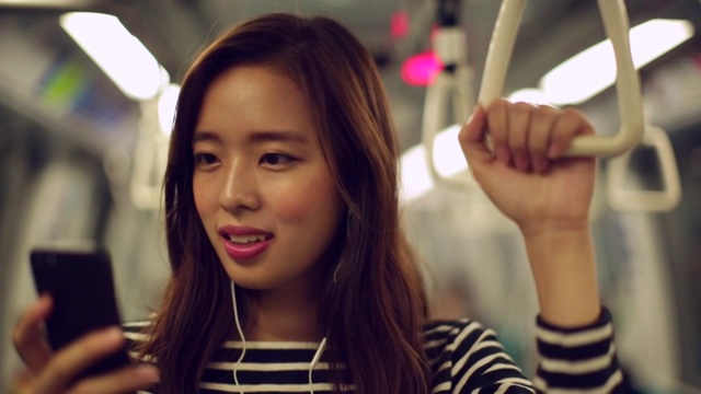 一名年轻女子在火车上使用手机视频素材