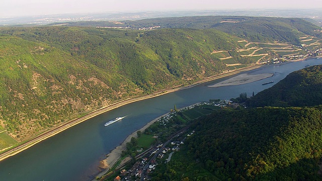 在德国莱茵河上游中部，拖船在河流和铁路沿线行驶的鸟瞰图视频下载
