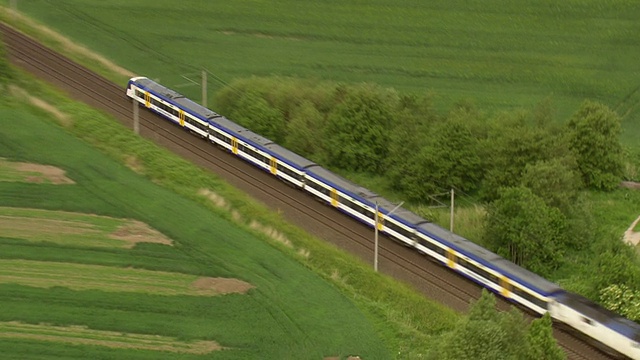 德国周围有农田和树木，火车在轨道上运行视频下载