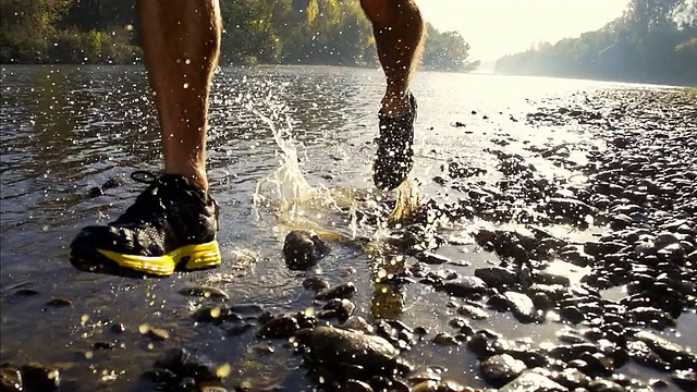 HD SUPER SLOW-MO:跑步者的鞋子溅水视频素材