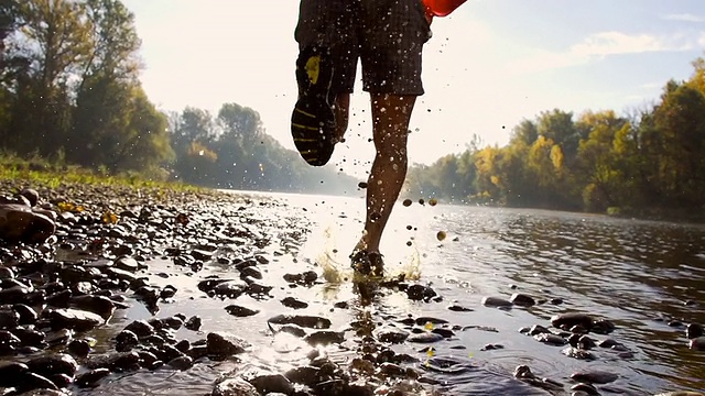 高清超级慢动作:奔跑者在河里溅水视频素材