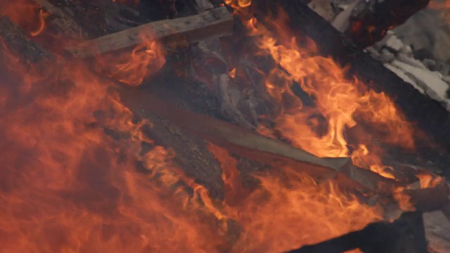 在一场房屋火灾中，火焰从一堆被烧成瓦砾的木料上升起视频素材