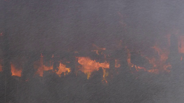 看不见的消防水龙带喷出的水花，落在被大火烧毁的房屋废墟上视频素材