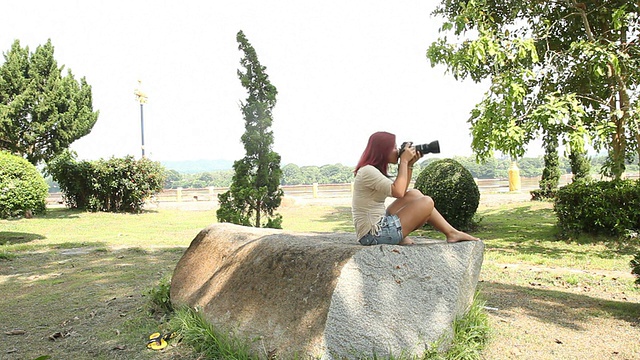 女性在公园里使用相机视频素材