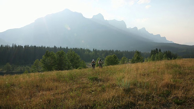 骑山地车穿过山地草地，日出视频素材