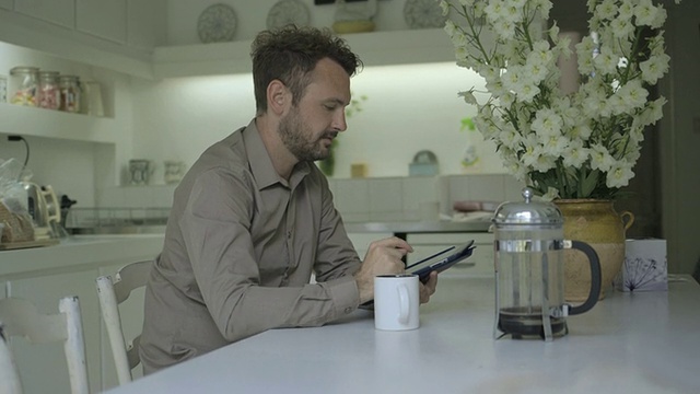 一边喝咖啡一边用平板电脑的男人。视频素材