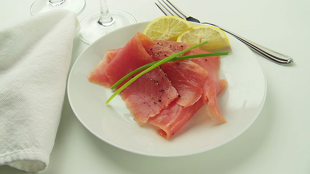 三文鱼在白色盘子上旋转，配上柠檬和莳萝视频素材