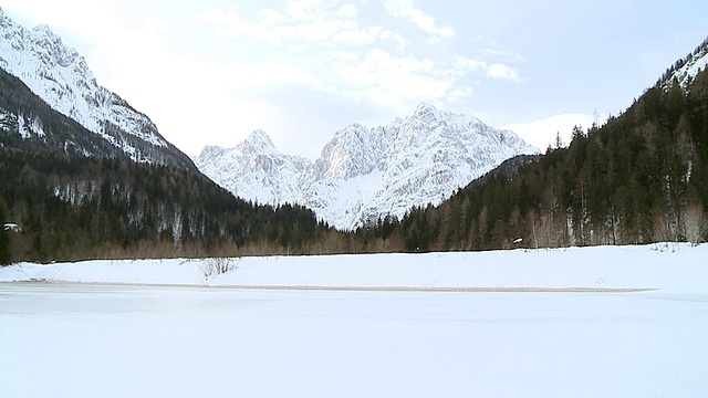 斯洛文尼亚Triglav Bohinj冰冻的湖和积雪覆盖远处的山视频素材