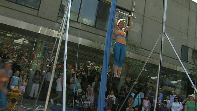 在加拿大安大略省多伦多市的街头艺人节上，女人把自己拉起来，用脖子吊在空中的画面视频素材