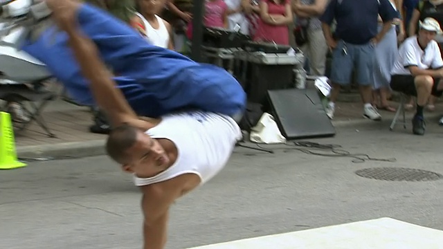 在加拿大安大略省多伦多市街头艺人节上，一名男子在表演混合舞蹈和体操动作视频下载