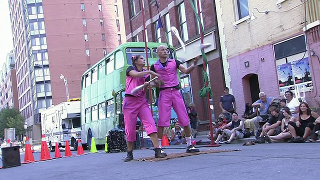 在加拿大安大略省多伦多市的街头艺术节上，两名杂耍演员用俱乐部一起表演视频素材