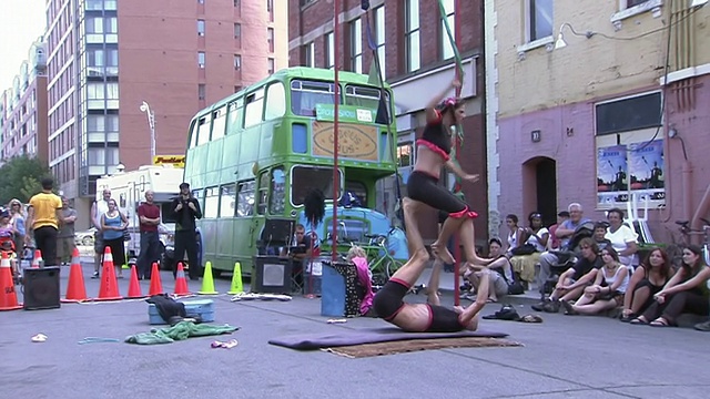加拿大安大略省多伦多市街头艺人节，一对夫妇在垫子上表演杂技视频素材