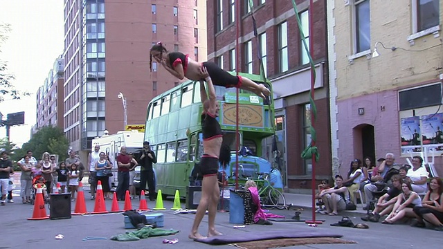 在加拿大安大略省多伦多市街头艺人节上，一对夫妇在垫子上表演杂技视频素材