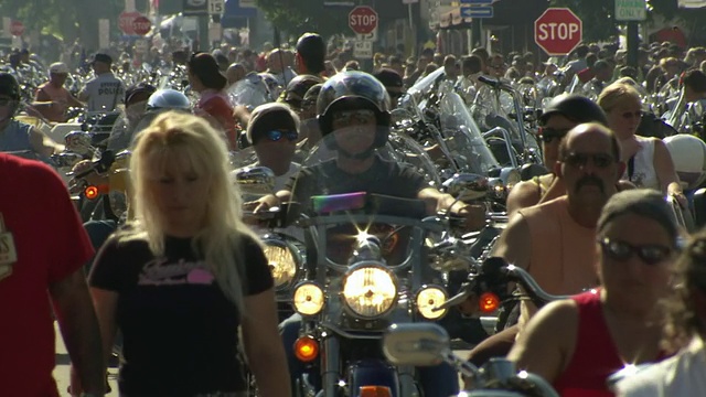 美国南达科塔州斯特吉斯摩托车拉力赛期间，几名摩托车手和行人在主要街道上巡游视频素材