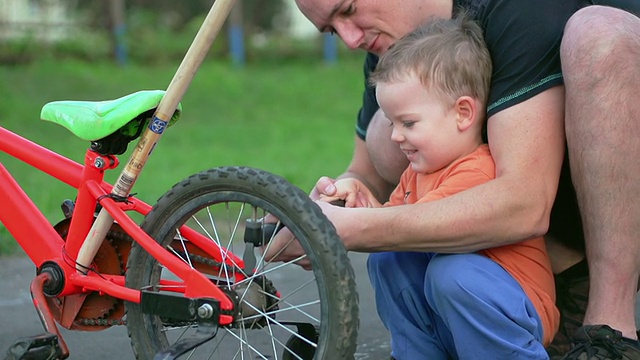 父亲和儿子在修理自行车轮胎视频素材