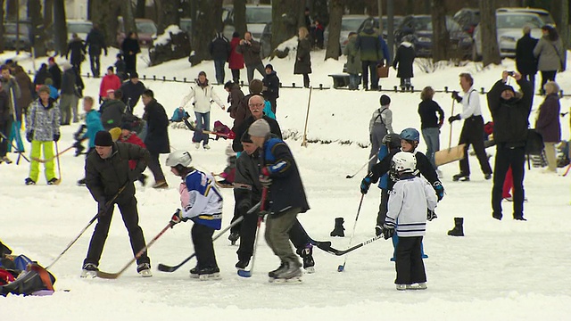 尼芬堡，人们在冰冻的河上，孩子和成年人在打冰球视频素材