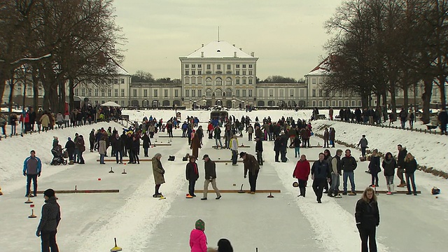 宁芬堡城堡，人们在冰封的河边，冰壶，城堡在背景中视频下载