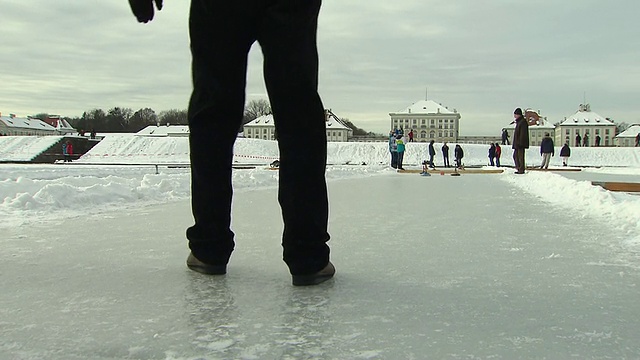 尼芬伯格，冰壶棍滑过冰面，一个男人的腿，后面是人视频下载