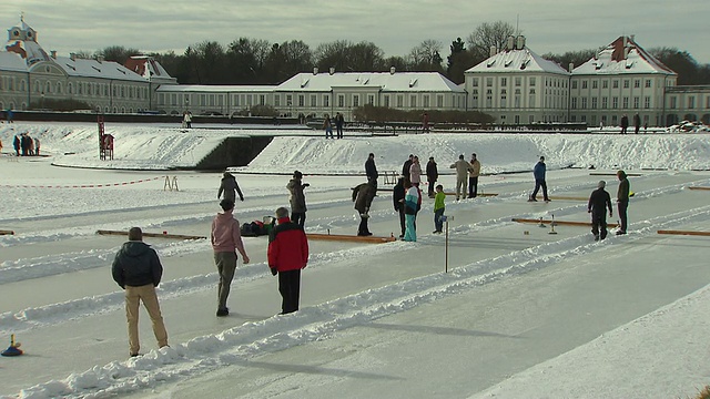 宁芬堡城堡，冰壶，有人在冰封的河面上，雪地上，城堡在背景中视频下载