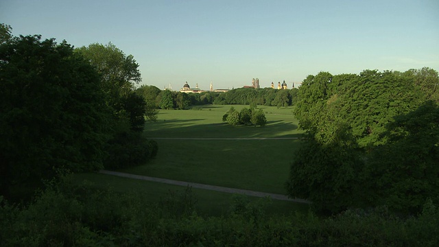 英国花园、草坪、树木、阳光、蓝天，映衬着慕尼黑的天际线视频素材
