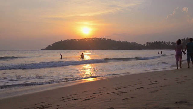 米瑞萨海滩，游客夫妇在日落时沿着海滩浪漫散步，斯里兰卡南海岸，亚洲视频素材