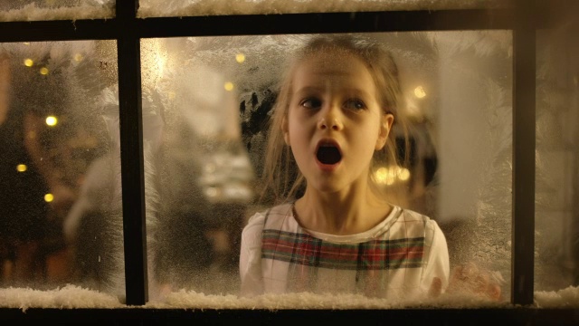 孩子们望着下雪的窗外视频素材