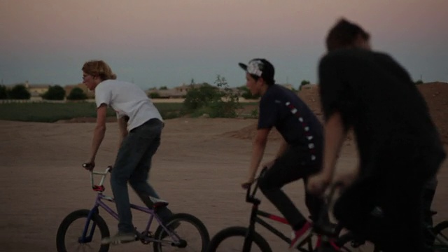 跟踪拍摄十几岁的男孩骑和跳BMX自行车视频下载