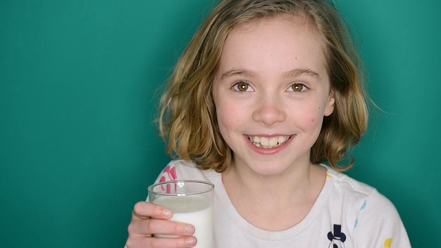 小女孩微笑着喝着牛奶/大伦敦，英国视频素材