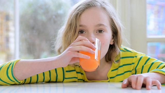 小女孩微笑着喝着果汁/大伦敦，英国视频素材