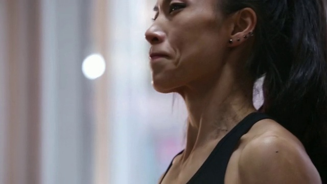 一个亚洲女性健身运动员在健身房做哑铃卷视频下载