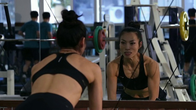 一个亚洲女性健身者在健身房做有线电视交叉视频素材