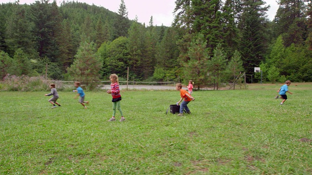 一群欢声笑语的小朋友在草地上打水球视频下载