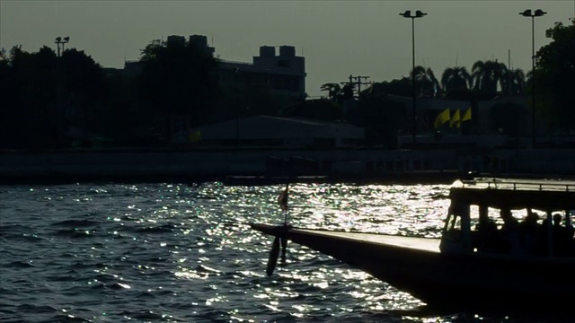 日落时河上漂浮的小船视频素材