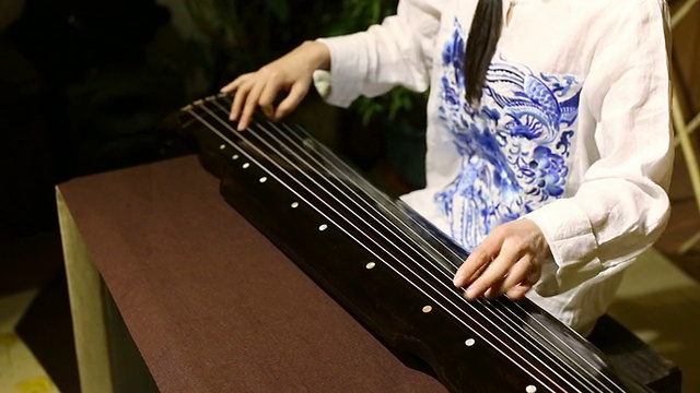 一个中国女人在玩古琴。视频素材