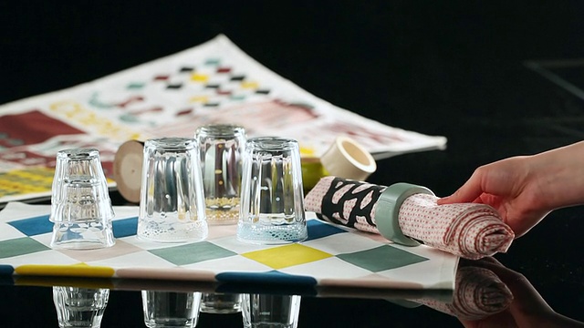 在黑色背景下，双手将玻璃和纺织品放在桌布上/首尔，韩国视频素材