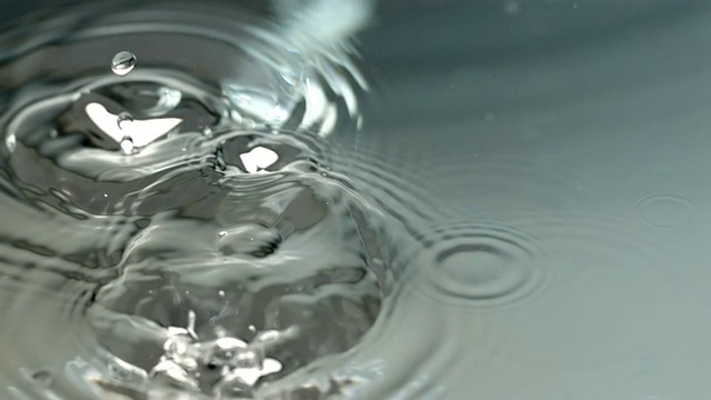 CU SLO MO拍摄的银色大理石和水滴滴入水中视频素材