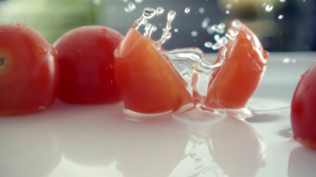CU SLO MO拍摄的一片圣女果落在装满水和圣女果的盘子里/韩国首尔视频素材