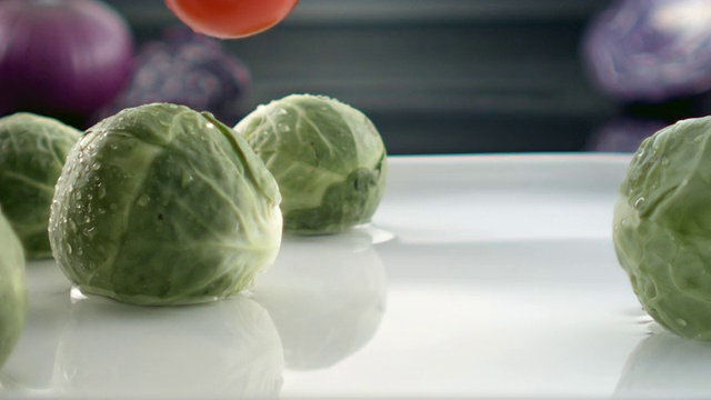 ECU SLO MO拍摄的卷心菜落在装满水和卷心菜的盘子上/韩国首尔视频素材