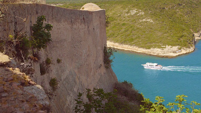 船经过古老的堡垒，多利拍摄于地中海的卡尔维科西嘉视频下载