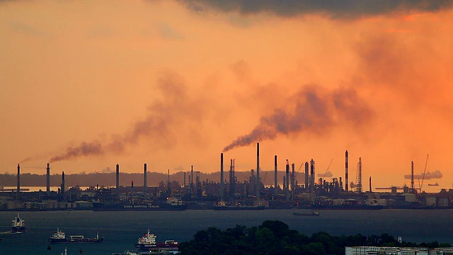 日落时，从工业区冒出的黑烟污染剪影。视频素材