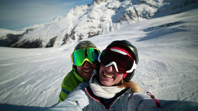 一对情侣在滑雪坡上自拍视频素材